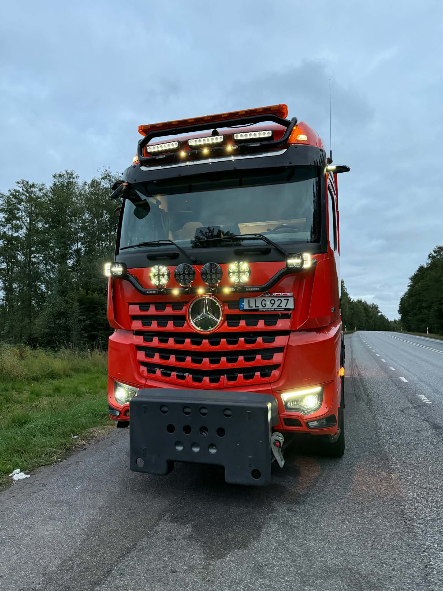 Örebro Vägmarkerings röda lastbil med lastväxlare på landsväg